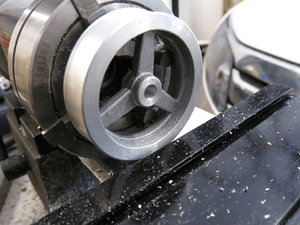 Flywheel on arbor and held in chuck to allow facing of remaining side